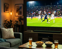 Cozy living room with a large TV showing a night soccer match